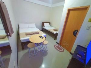 a small room with a bed and a table and chairs at JRJ Lodge in San Carlos