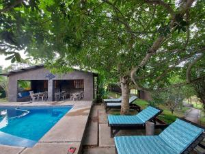 a swimming pool with blue chairs and a house at Emoyeni Eco Lodge in Sodwana Bay