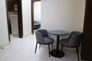 a table and two chairs in a room at Binayat Hama Serviced Apartments - Standard in Al Jubail