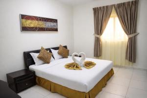 a bedroom with a large white bed with a window at Binayat Hama Serviced Apartments - Standard in Al Jubail +50 photos