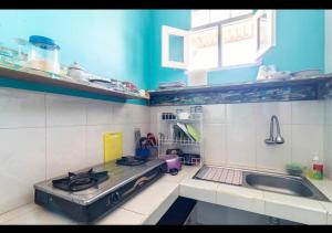 a small kitchen with a stove and a sink at Isin Gumi Homestay in Amed