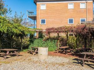 a group of picnic tables in front of a building at 4 person holiday home on a holiday park in Hejls in Hejls