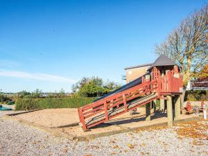 a playground in a park with a red play structure at 4 person holiday home on a holiday park in Hejls in Hejls
