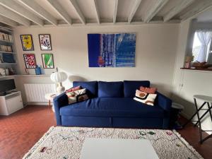 a blue couch sitting in a living room at Cottage with Garden 5mn Beach in Cabourg