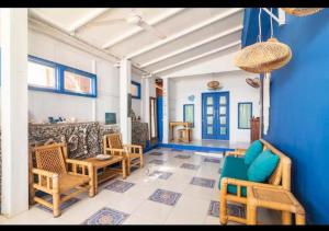 a living room with chairs and a blue wall at Isin Gumi Homestay in Amed