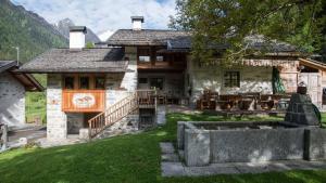 a large house with a patio and a table at Baite Di Pra in Spiazzo
