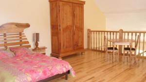 a bedroom with a bed and a table and a wooden cabinet at Gîte de Très Bayard in Saint-Claude