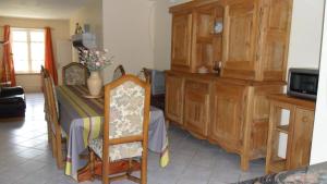 a dining room with a table and a kitchen at Gîte de Très Bayard in Saint-Claude +4 photos