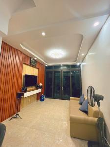 a living room with a couch and a tv at Êm Tiny in Hai Phong