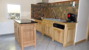 a kitchen with wooden cabinets and a sink at Gîte de Très Bayard in Saint-Claude