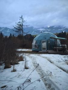 a tent in a field with snow on the ground at Wild Glamping Liptov in Liptovský Ondrej