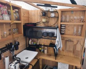 a kitchen with wooden cabinets and a counter top at Wild Glamping Liptov in Liptovský Ondrej