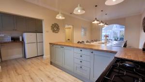 a kitchen with white cabinets and a white refrigerator at Woodlands in Benllech