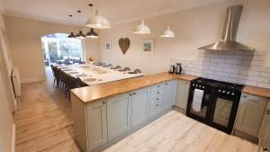 a kitchen with a long counter and a dining room at Woodlands in Benllech