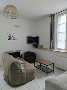 a living room with a couch and a table at Appartement montagne in Eaux-Bonnes