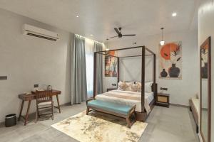 a bedroom with a canopy bed and a desk at Kaizen Eirene Luxe Villas, Udaipur in Nāi +199 photos