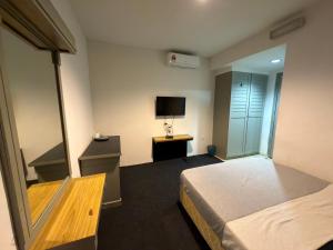 a hotel room with a bed and a television at MyPlace Sri Cemerlang Kota Bharu in Kota Bharu