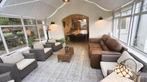 a living room with a couch and chairs and a table at Woodlands in Benllech +38 photos
