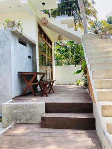 a porch with a wooden table and a bench at Layday Surf Ahangama in Ahangama