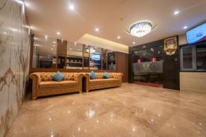 a lobby with two couches and a tv at Shyanu Lords Eco Inn Airoli-Near Mindspace in Navi Mumbai