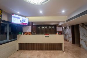 a restaurant with a counter with clocks on the wall at Shyanu Lords Eco Inn Airoli-Near Mindspace in Navi Mumbai