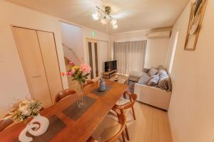 a living room with a dining room table and a couch at ｾ-ﾇeast in Takasaki