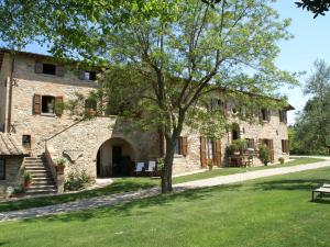 un antiguo edificio de piedra con un árbol en el patio en Spacious Holiday Home in Montone, en Montone