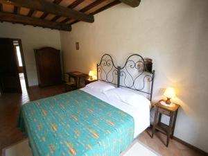 1 dormitorio con 1 cama y 2 mesas con lámparas en Spacious Holiday Home in Montone, en Montone