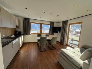 a kitchen and living room with a table and a couch at Apart Hotel Neier in Ladis