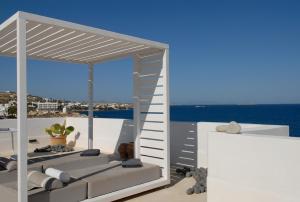 a white room with a bed and a ladder at Villa Kastro in Parikia
