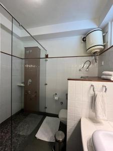 a bathroom with a shower and a toilet and a sink at Johnson Lodge Manali in Manāli