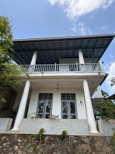 a white house with a balcony on top of it at Far view villa in Galle