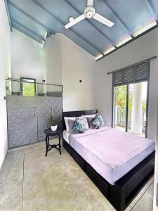a bedroom with a large bed with a ceiling fan at Far view villa in Galle