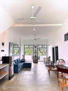 a living room with a blue couch and a ceiling fan at Far view villa in Galle