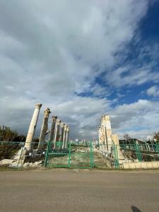 a fence in front of a building with columns at Solia Hotel in Mezitli