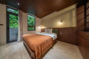 a bedroom with a bed and a window at 安樓文旅 Enzo House in Keelung