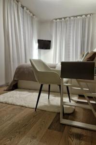 a bedroom with a bed and a chair and a desk at Pension Villa Grün in Zwickau