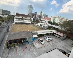 a building with two cars parked in a parking lot at โรงแรมวินบางนา Win Bangna Hotel in Bangna