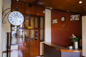 a clock on the wall above the entrance to a institution at Grosvenor Hotel in Nuwara Eliya