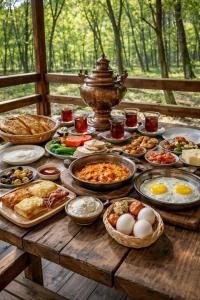 a wooden table with many plates of food on it at Colorato Quba in Qırmızı Qǝsǝbǝ