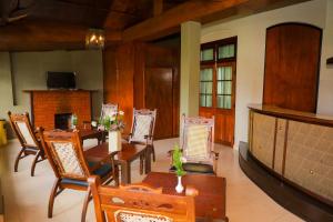 a dining room with tables and chairs and a fireplace at Grosvenor Hotel in Nuwara Eliya