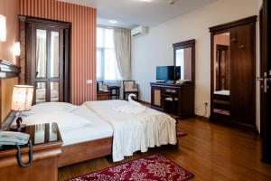 a hotel room with a bed and a desk at Acapulco Hotel in Ploieşti