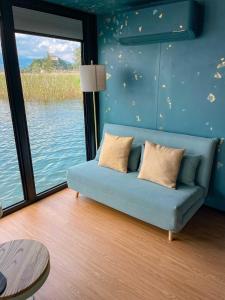 a blue couch in a room with a large window at Celesia SKy Water Andromeda in Sesto Calende
