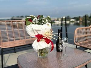 a table with a bouquet of flowers and a bottle of wine at Celesia SKy Water Andromeda in Sesto Calende