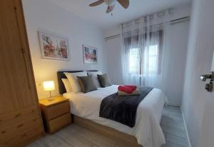 a bedroom with a white bed with a lamp and a window at Hervas Centro Apartamento IDEAL FAMILIAS 6 adultos y 2 niños- in Hervás