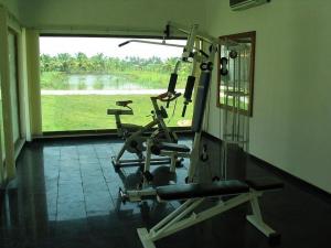 a gym with two tread machines in a room with a window at Manor Backwater Resort in Kumarakom