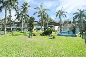 a house with a yard with a pool and palm trees at Manor Backwater Resort in Kumarakom