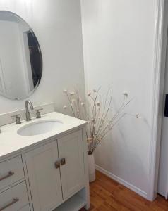 a white bathroom with a sink and a mirror at Flossies in Seabrook