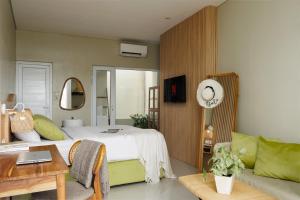 a bedroom with a large bed and a couch at Deva Bali Apartement in Kerobokan