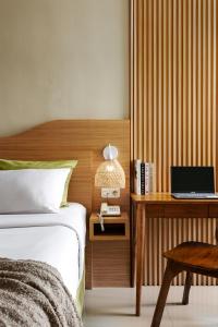 a bedroom with a bed and a desk with a laptop at Deva Bali Apartement in Kerobokan